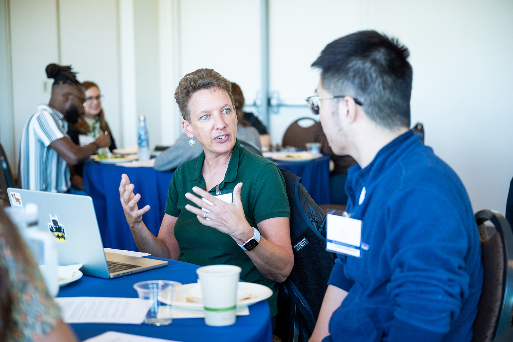 photo of people seated around circular tables conversing
