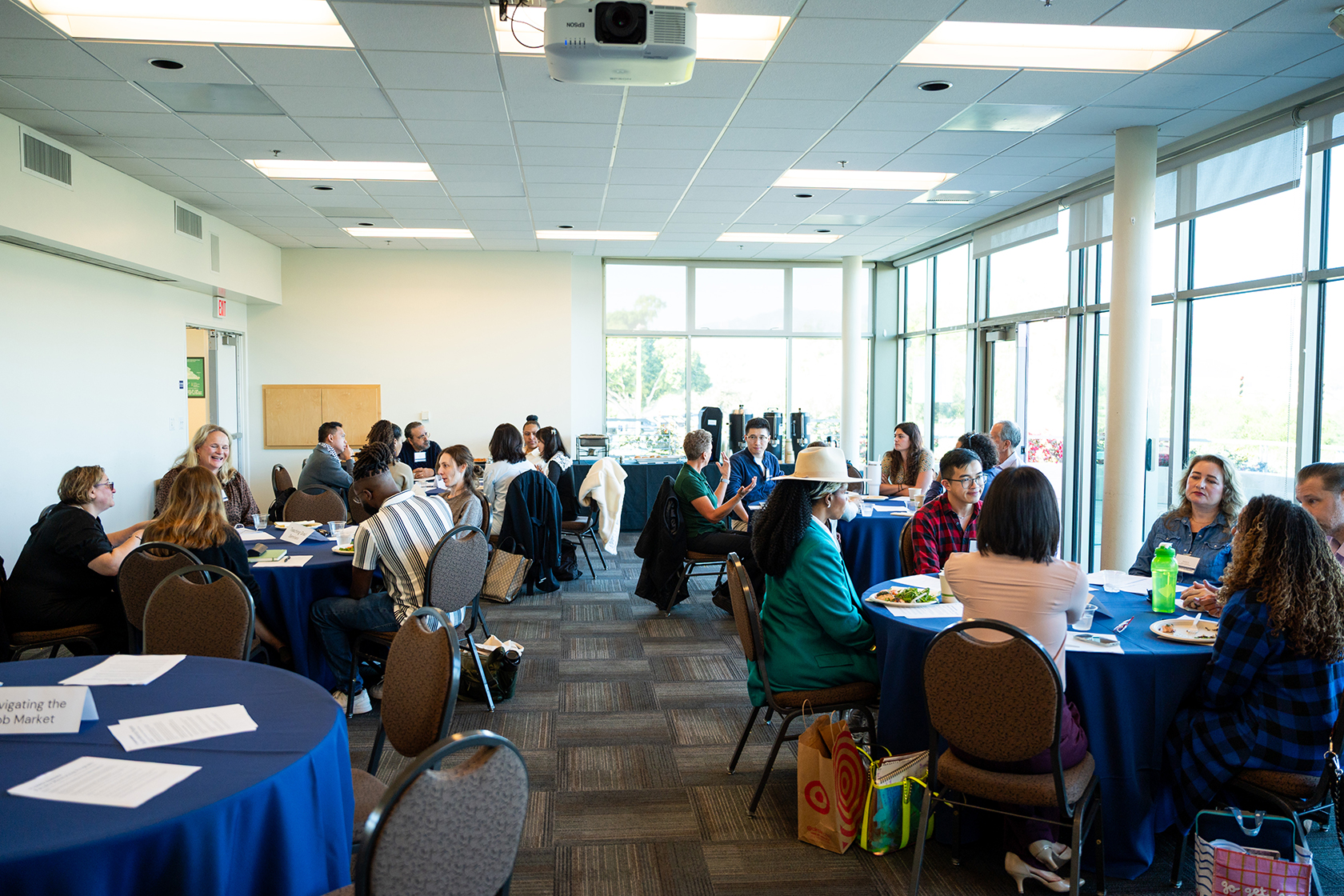 room of people seated around circular tables