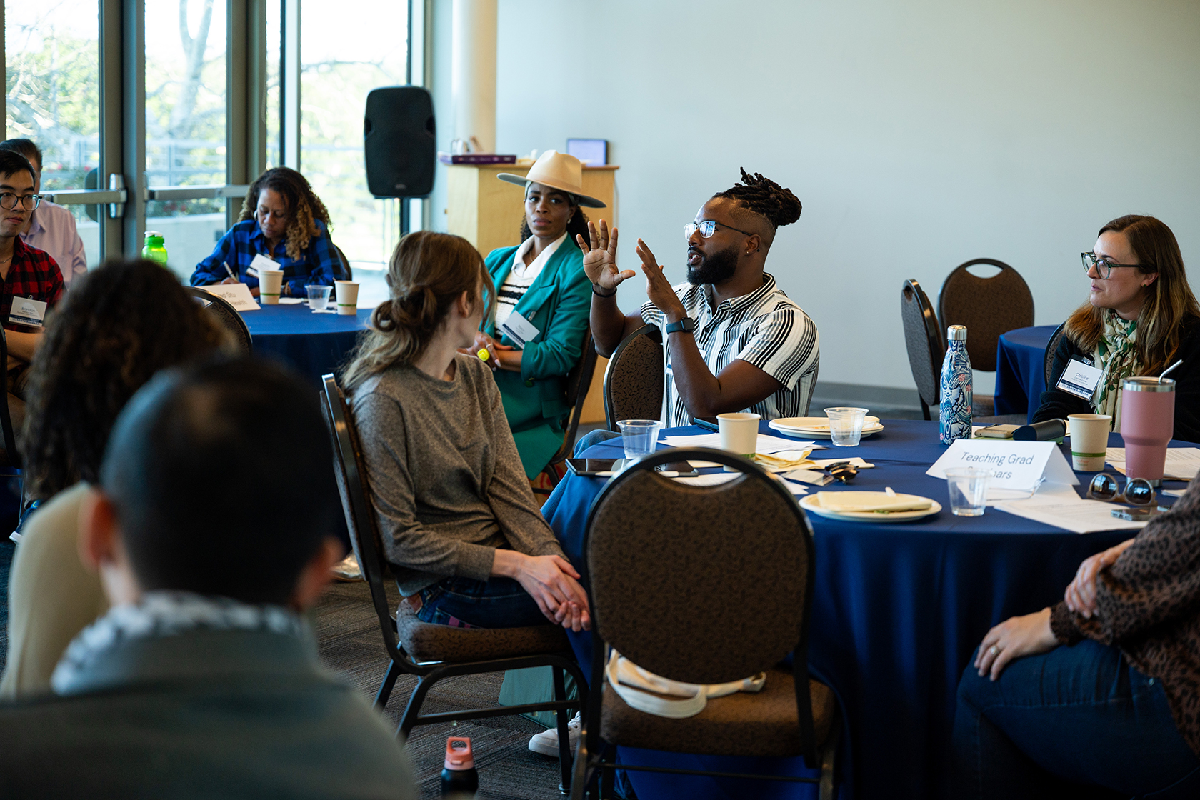 room of people seated around circular tables