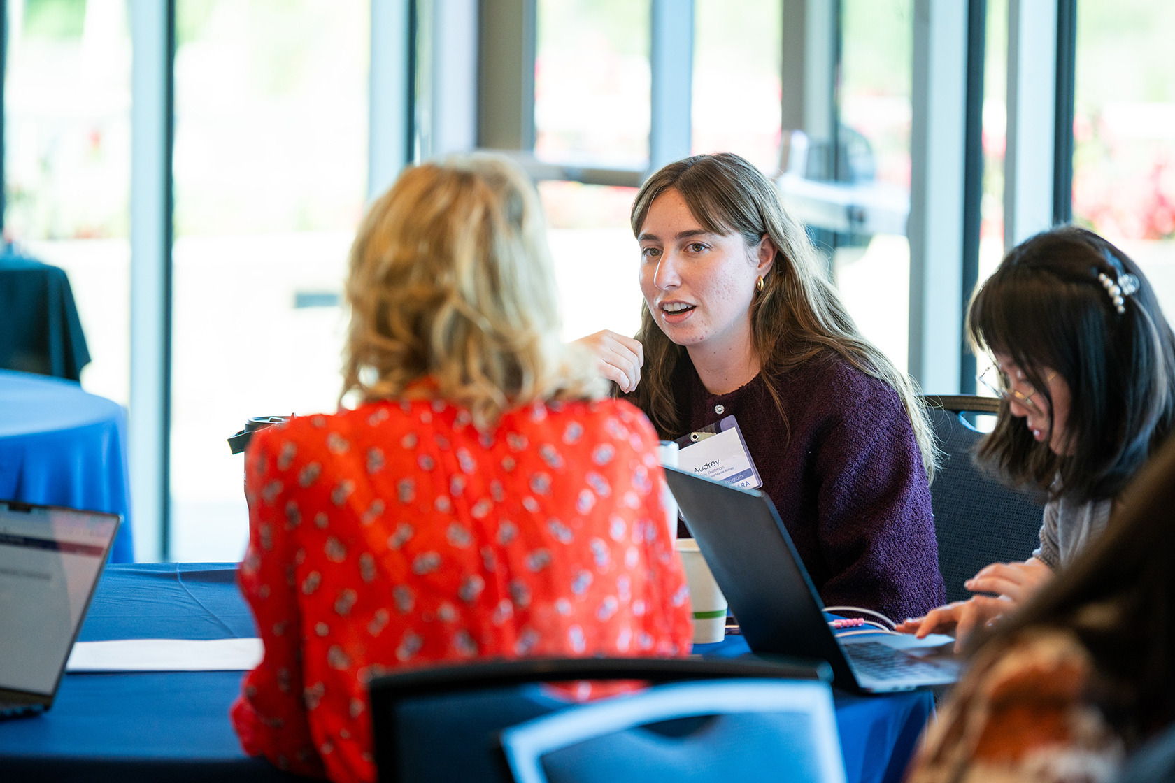 three people seated while two have a discussion