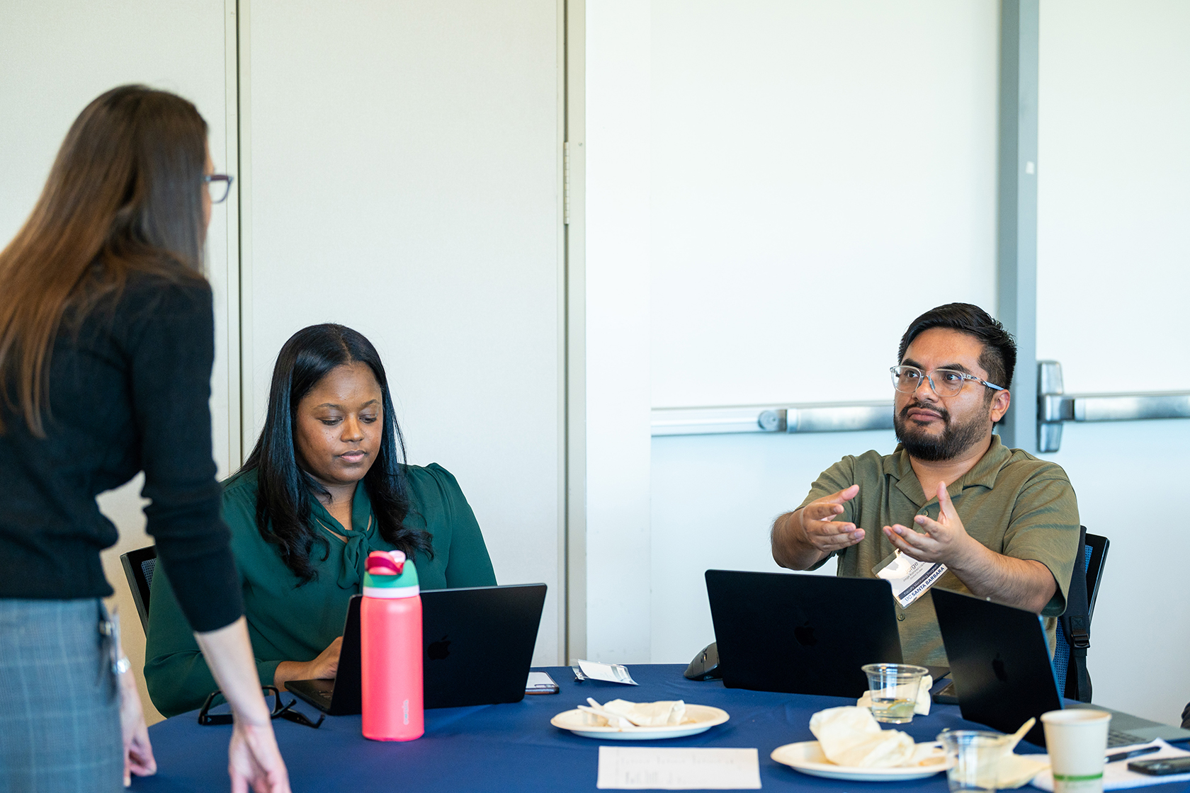 two people seated one having a discussion with a standing person