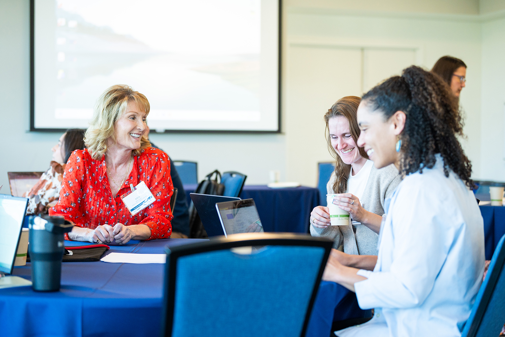 three seated people at a table in conversation