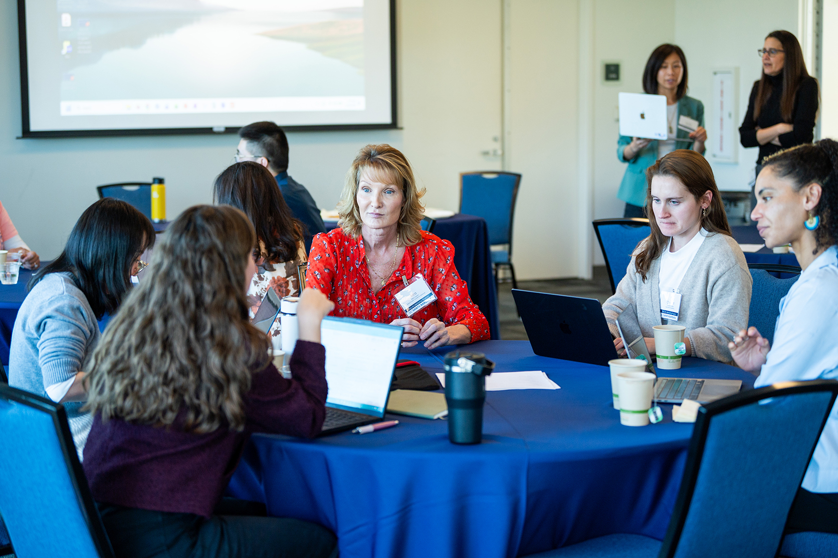 room of people seated around circular tables