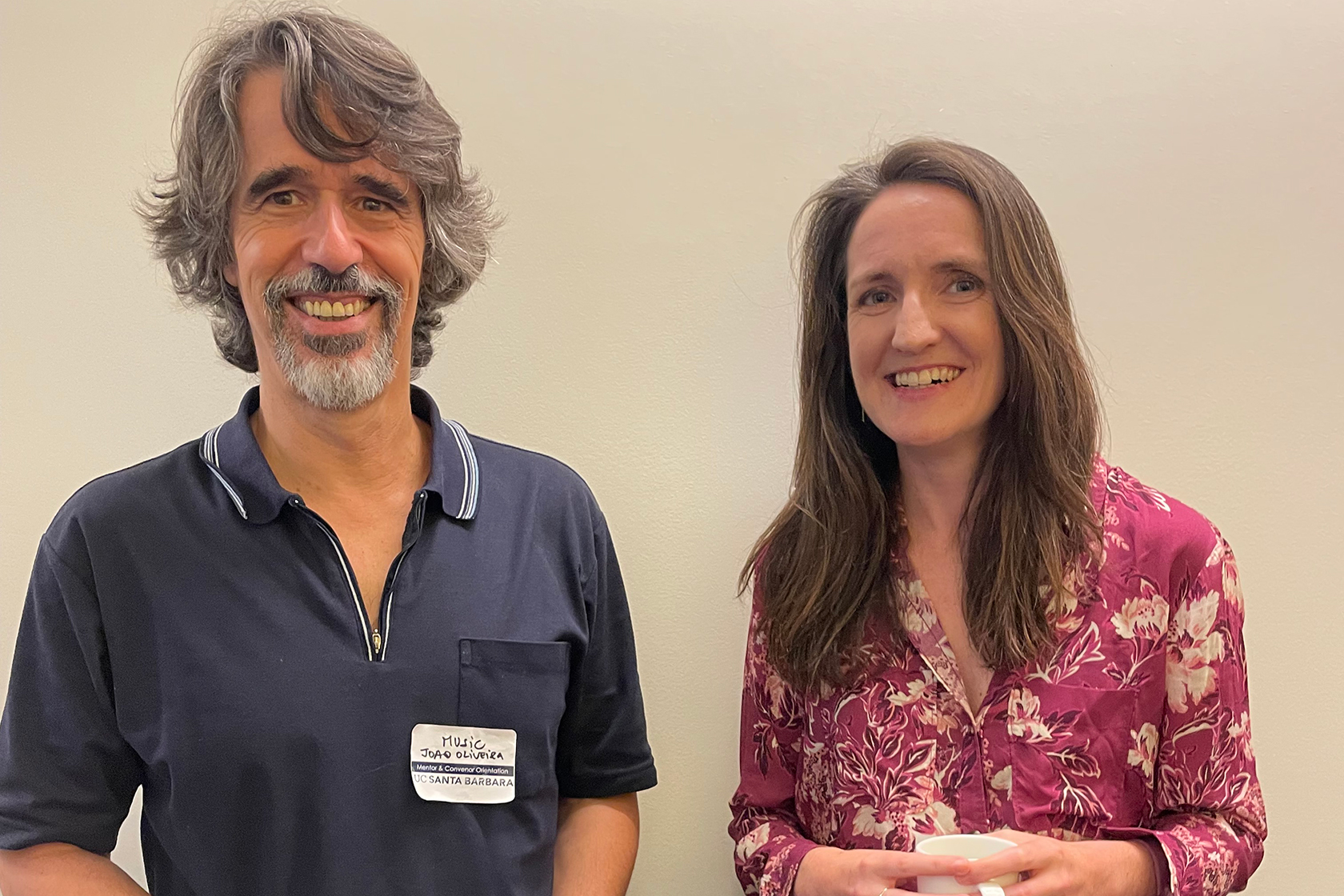 two people facing forward one in a blue shirt one a magenta-patterned shirt