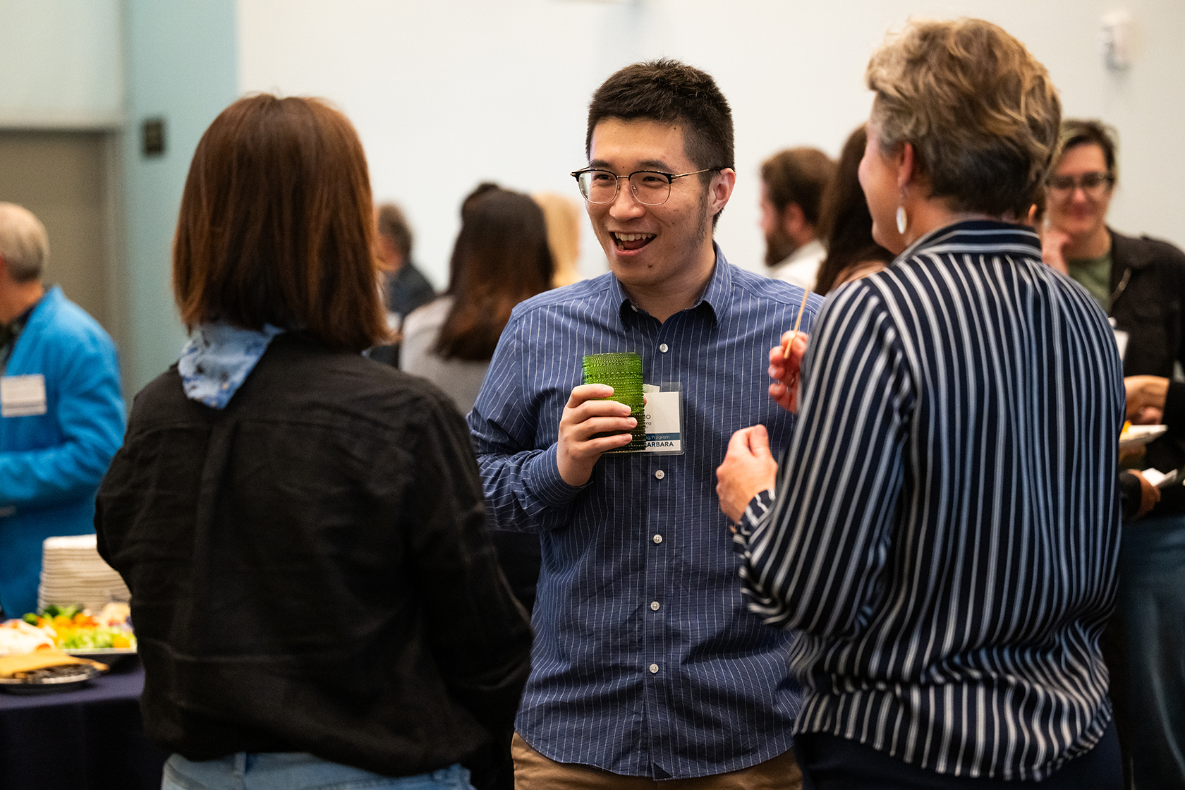 small group of people holding drinks and conversing
