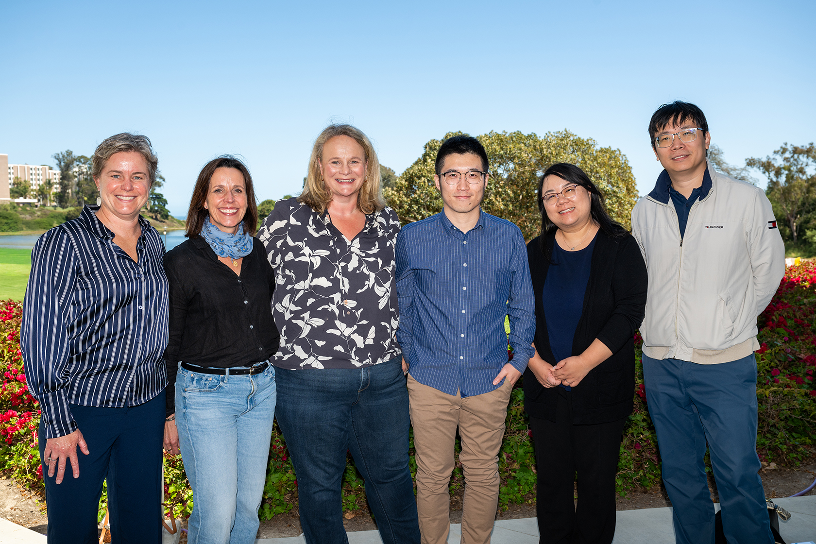 six people posing for a picture outside