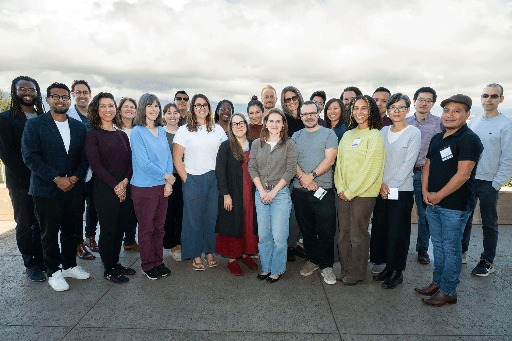 group of standing people with a cloudy background