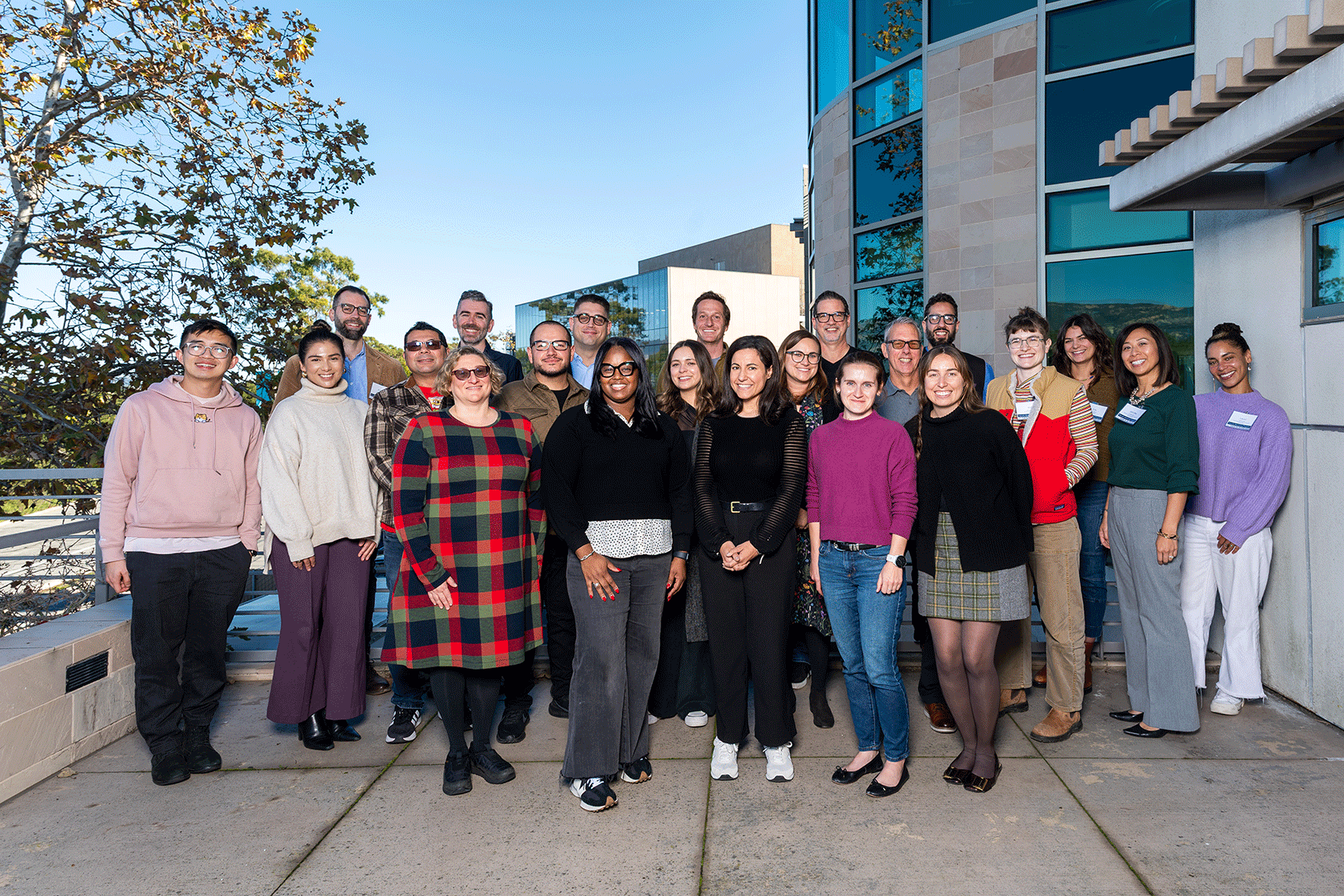 group of twenty two people standing outside posing for a photo